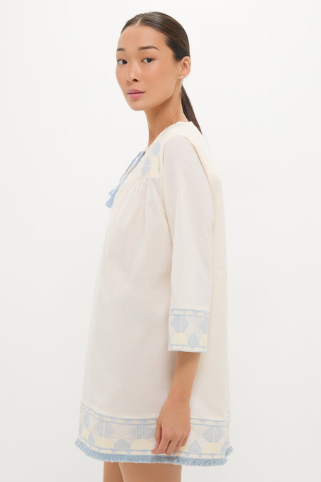 Young woman models the classic Neblina Geometric Embroidered Bondi Coverup, showcasing its effortless, high-end design with fun geometric embroidery and a fringe trim.