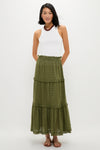 Woman in classic, effortless Fern Eyelet Prado Skirt featuring tiered layers and ruffled hem, styled with a high-neck tank top, sandals, and beaded necklace, exuding fun sophistication.