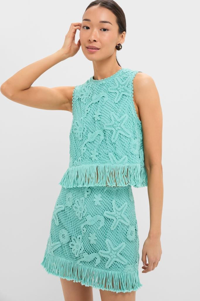 Model in the Teal Samia Fringe Set: a classic, effortless crochet outfit featuring starfish motifs, sleeveless crop top, and mini skirt with fringe, embodying fun, high-end style.