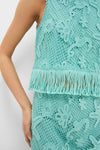 Woman in a classic, high-end Teal Samia Fringe Set featuring a sleeveless crochet crop top and matching skirt, showcasing effortless style with fun fringe detailing.