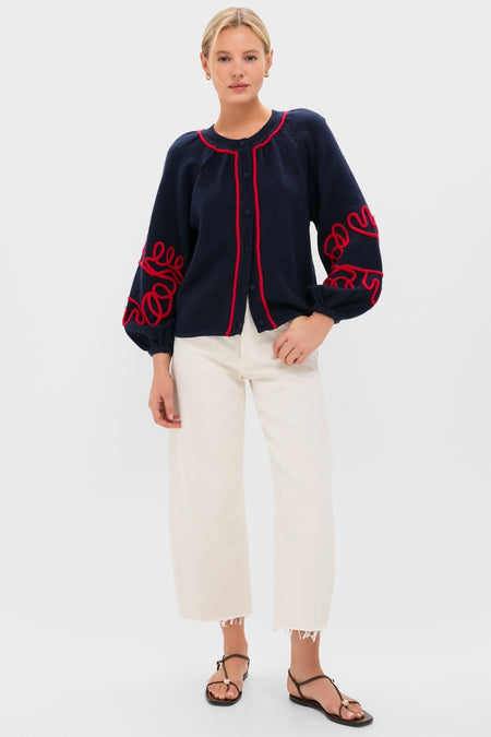 Woman wearing the classic Navy & Red Soutache Stella Cardigan with fun red details, paired with effortless high-end off-white jeans and black sandals, embodying Tuckernuck's cool, confident style.