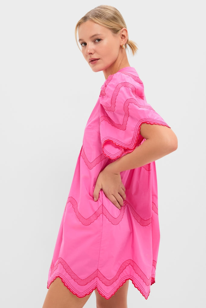 Woman in profile wearing the Hot Pink with Red Embroidery Weston Mini Dress, featuring effortless scalloped details and classic zigzag edges, exuding a fun, high-end style.