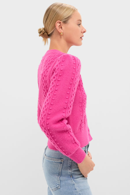 Profile of a woman in a bright pink, cable-knit Hot Pink Embroidered Floral Frankie Cardigan, exuding a classic and effortless charm, paired with light-wash jeans.