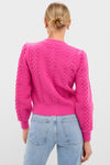 Back view of a person wearing the classic, high-end Hot Pink Embroidered Floral Frankie Cardigan, effortlessly styled with light-wash jeans, embodying fun and confident elegance.