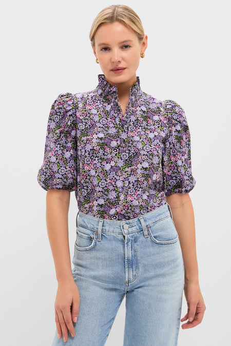 Model in a classic, high-neck Shades of Purple Floral Florence Blouse paired with light-wash jeans, embodying an effortless and fun high-end style.