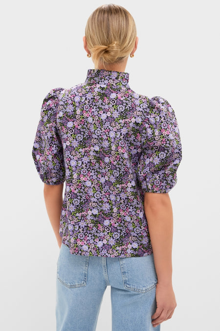 Person wearing the classic Shades of Purple Floral Florence Blouse with puffed sleeves, paired with light-wash jeans; an effortless, high-end look from Tuckernuck.