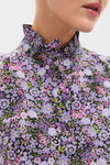 Close-up of the Shades of Purple Floral Florence Blouse, featuring a classic high-collared design with a ruffled tie, showcasing an effortless and fun floral pattern.