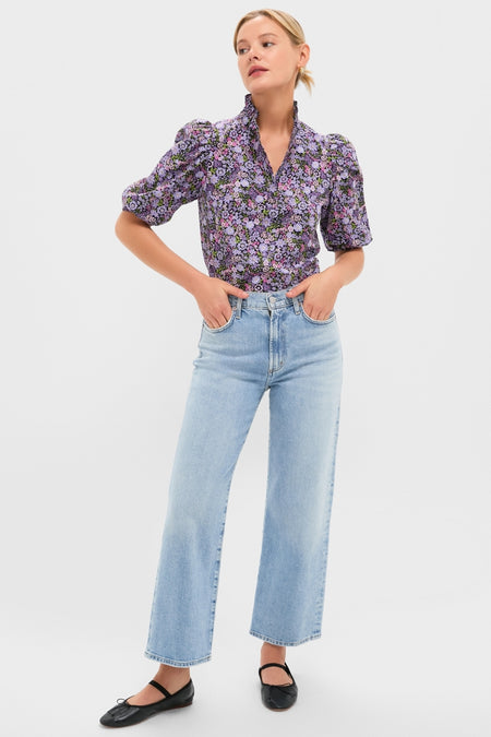 Woman wearing the Shades of Purple Floral Florence Blouse, a classic V-neck, effortlessly styled with high-waisted jeans and black ballet flats, embodying a fun, high-end look.