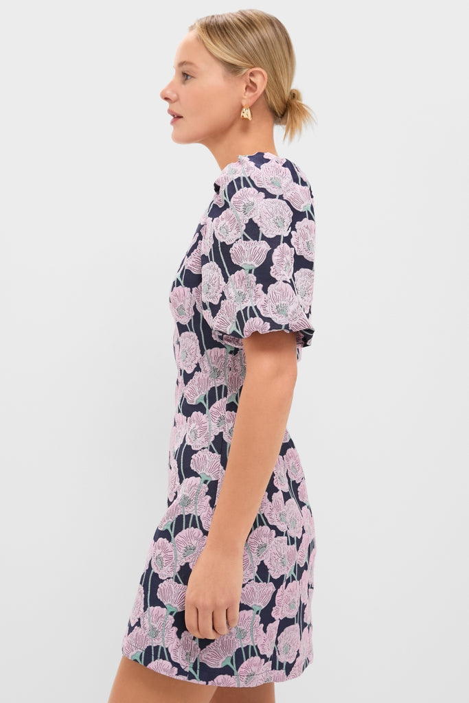 Woman in Pink & Navy Floral Jacquard Minetta Mini Dress, showcasing classic and effortless style with puffed sleeves and poppy motifs, epitomizing Tuckernuck's fun, high-end fashion.