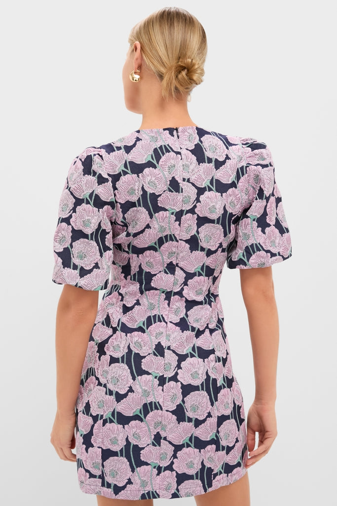 Person wearing the Pink & Navy Floral Jacquard Minetta Mini Dress, showcasing its bold floral print and puffed sleeves for a classic, effortless, and fun high-end look.