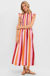 Woman models the classic Orange, Pink & Crimson Stripe Smocked Sully Dress, featuring a smocked bodice, ruffle cap sleeves, and an effortless A-line silhouette, paired with fun brown sandals.