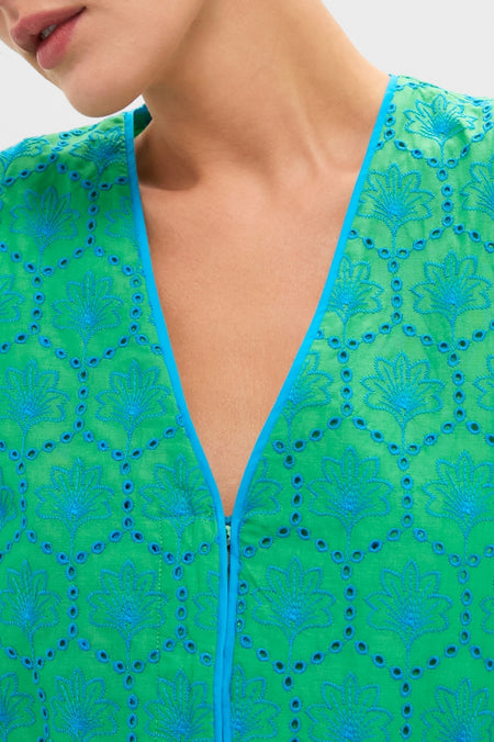 Seafoam Palm Eyelet Mini Arem Caftan showcases classic elegance with its effortless floral motif, bright blue embroidery, and fun eyelet details on a high-end green fabric.