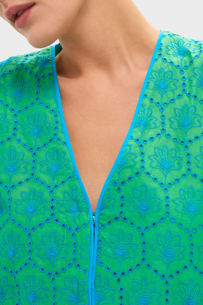 Seafoam Palm Eyelet Mini Arem Caftan showcases classic elegance with its effortless floral motif, bright blue embroidery, and fun eyelet details on a high-end green fabric.