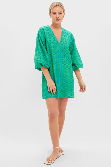 Model wears the Seafoam Palm Eyelet Mini Arem Caftan, a classic, effortless tunic with geometric eyelet pattern, V-neck zipper, and puffed sleeves, paired with white sandals.