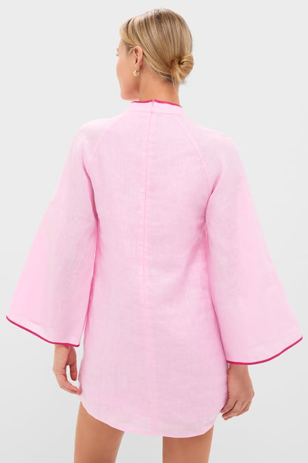 Woman in a light-pink Pink Seashell Oceana Mini Dress with bell sleeves, showcasing its classic, effortless design and high-end feel.