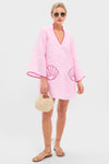 Woman models the Pink Seashell Oceana Mini Dress, a classic, effortless tunic-style piece with scallop-shell details, paired with fun sunglasses and high-end accessories.