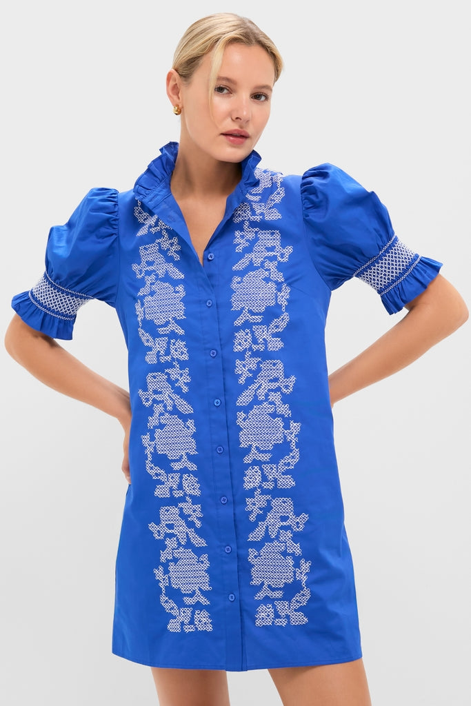Model wearing the Royal Blue with White Embroidery Lou Lou Mini Dress, showcasing classic, effortless style with puffed sleeves, ruffled collar, and high-end floral embroidery.