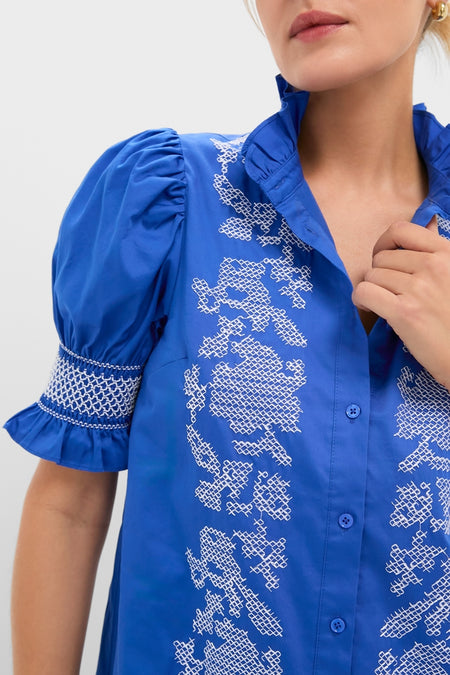 Woman wearing a classic Royal Blue with White Embroidery Lou Lou Mini Dress, featuring puffed sleeves and elegant embroidery, exuding an effortless and fun high-end style.