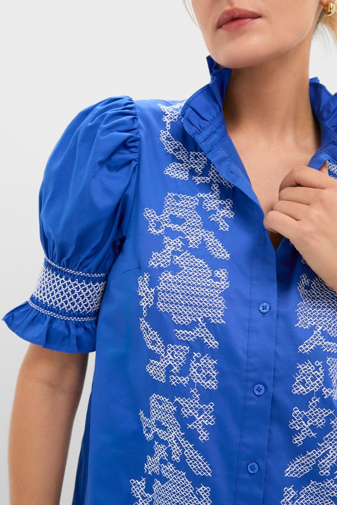 Woman wearing a classic Royal Blue with White Embroidery Lou Lou Mini Dress, featuring puffed sleeves and elegant embroidery, exuding an effortless and fun high-end style.