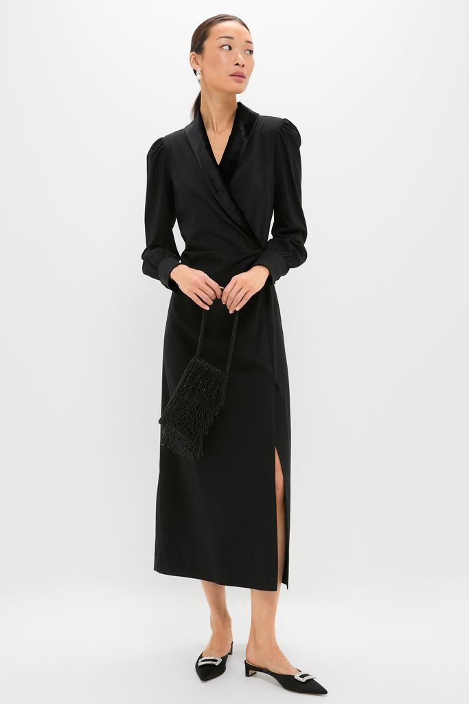 Black Long Sleeve Mariella Midi Dress exudes classic sophistication with its wrap style, velvet details, and side slit, paired effortlessly with a chic fringe-bead bag.