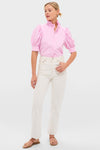 Model in Pink Candy Stripe Louisa Blouse with ruffled collar and puffed sleeves, tucked into off-white jeans, showcasing a classic, effortless, and fun high-end style.