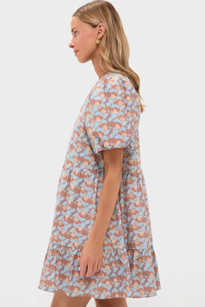 Woman in profile wearing a classic, effortless Brown & Powder Blue Floral Zip Front Ellie Mini Dress with puff sleeves, embodying fun and high-end style.