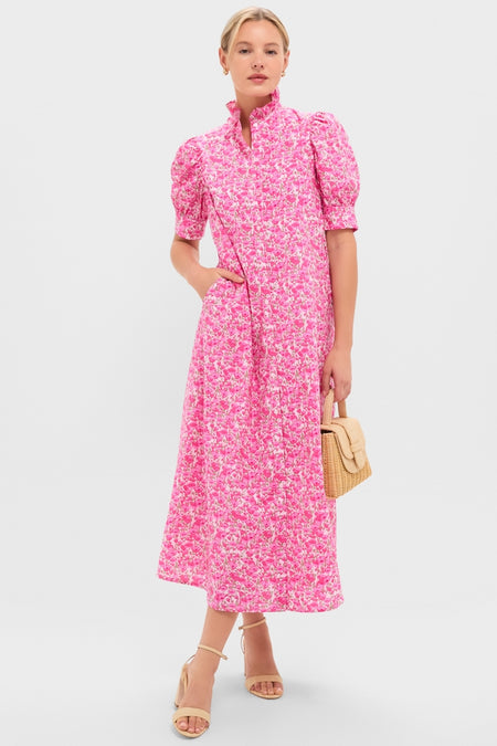 Model in Pink Poppies Floral Louisa Maxi Dress with puff sleeves, classic high collar, and effortless style, holding a woven handbag. Perfect for a fun, high-end look.