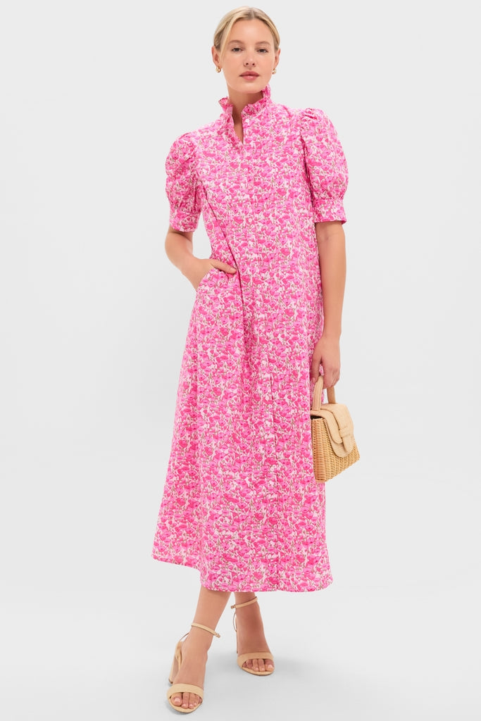 Model in Pink Poppies Floral Louisa Maxi Dress with puff sleeves, classic high collar, and effortless style, holding a woven handbag. Perfect for a fun, high-end look.