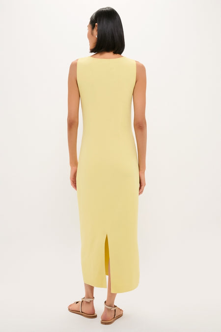 Person wearing the classic Lemongrass Kingston Knit Dress, an effortless chic midi with a back slit, styled with tan flat sandals. Perfect for a fun, high-end look.