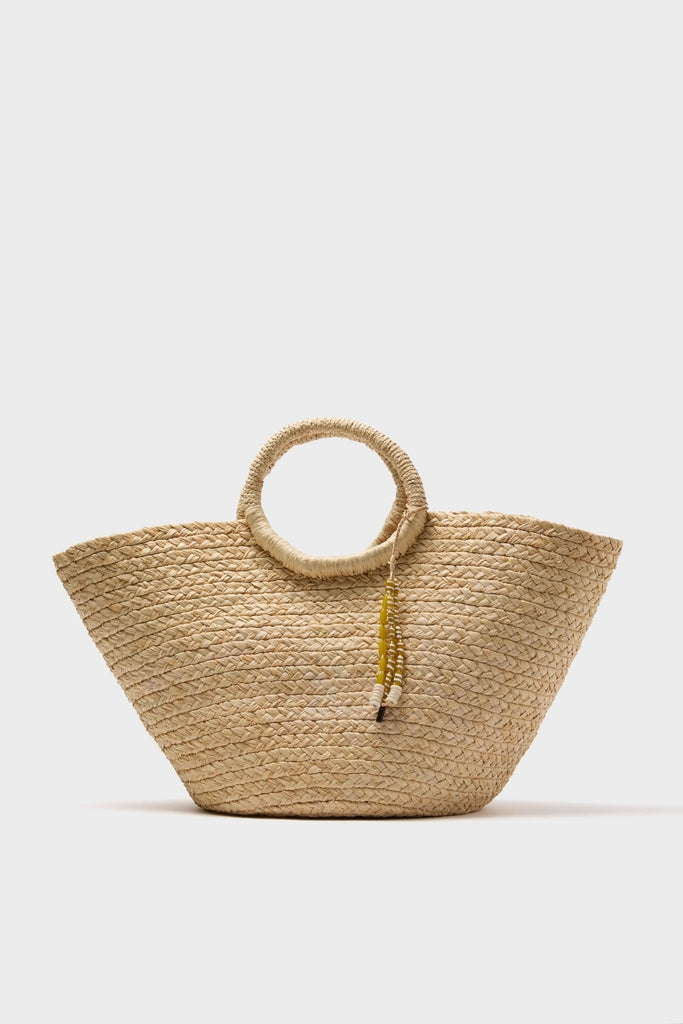 Natural Mimi Basket: A classic woven straw tote with circular handles and a playful tassel, offering an effortless, high-end look for fun getaways.