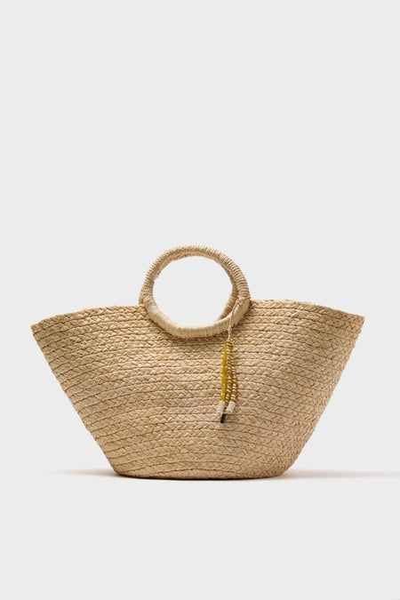 Natural Mimi Basket: A classic woven straw tote with circular handles and a playful tassel, offering an effortless, high-end look for fun getaways.