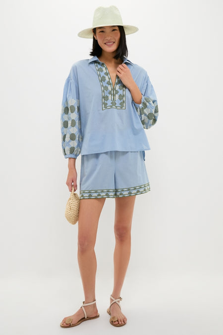 Woman in a classic, loose-fit light blue set with a Sage Novelty Packable Hat, exuding effortless style; perfect for a fun, high-end getaway.