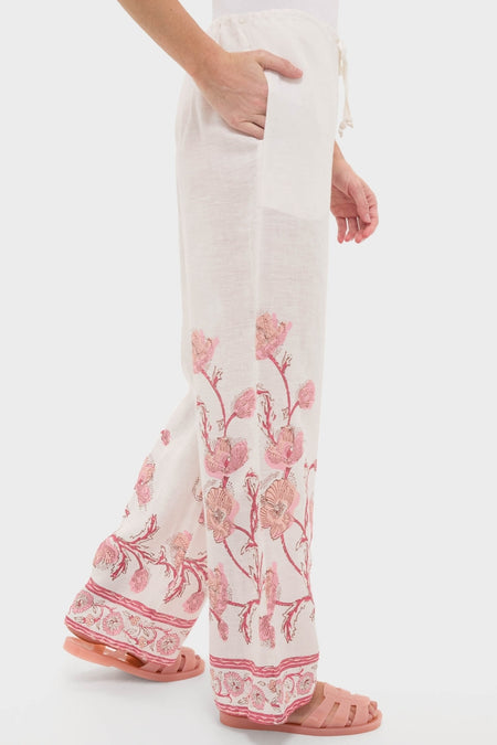 Side view of Hibiscus Bloom Pink Florentine Pants, featuring classic wide-leg linen design with floral embroidery and effortless style, paired with pink slip-on sandals.