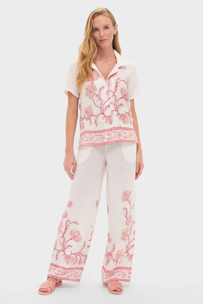 Model showcasing classic Hibiscus Bloom Pink Florentine Pants with hand-printed floral details, offering an effortless, high-end look. Paired with a matching shirt for a fun, coordinated style.