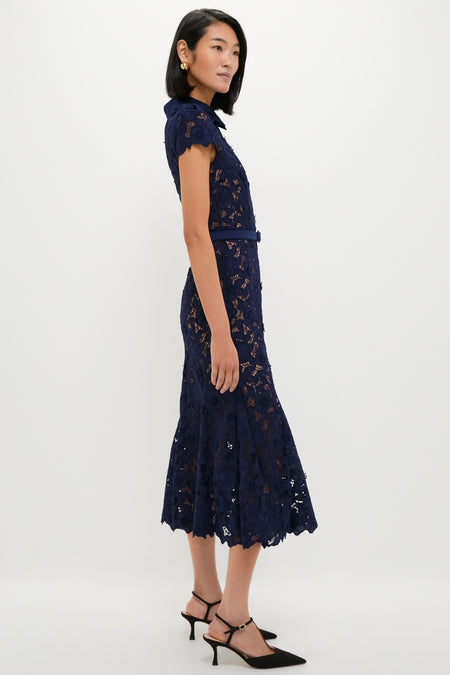Navy Guipure Lace Midi Dress exudes classic elegance with its fitted waist, scalloped hem, and cap sleeves, paired effortlessly with black slingback pumps for a fun, high-end look.