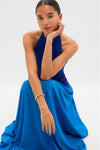 Young woman models the Cosmic Blue Soglio Halter Maxi Dress, featuring a classic halter neckline and effortless flow, embodying Tuckernuck's fun, high-end style.
