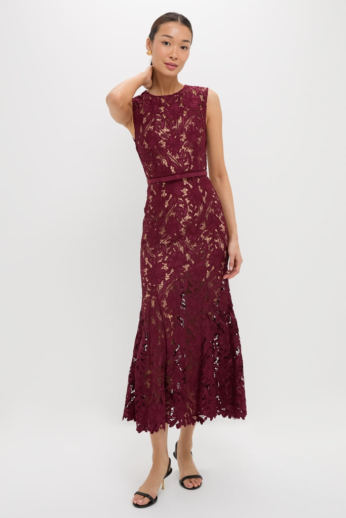 Woman models the classic Burgundy Guipure Lace Midi Dress; an effortlessly high-end piece with a fitted bodice and flared scalloped hem, paired with black heels.