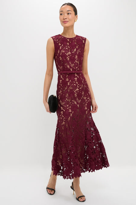 Model in a classic Burgundy Guipure Lace Midi Dress with fitted bodice, scalloped hem, holding a black clutch, embodying effortless elegance and high-end style.