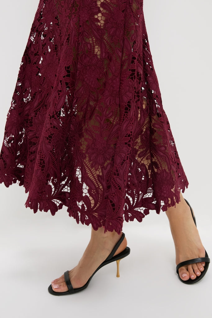 Effortlessly chic, the Burgundy Guipure Lace Midi Dress pairs with classic black slingback sandals featuring gold stiletto heels, capturing a high-end, fun style.