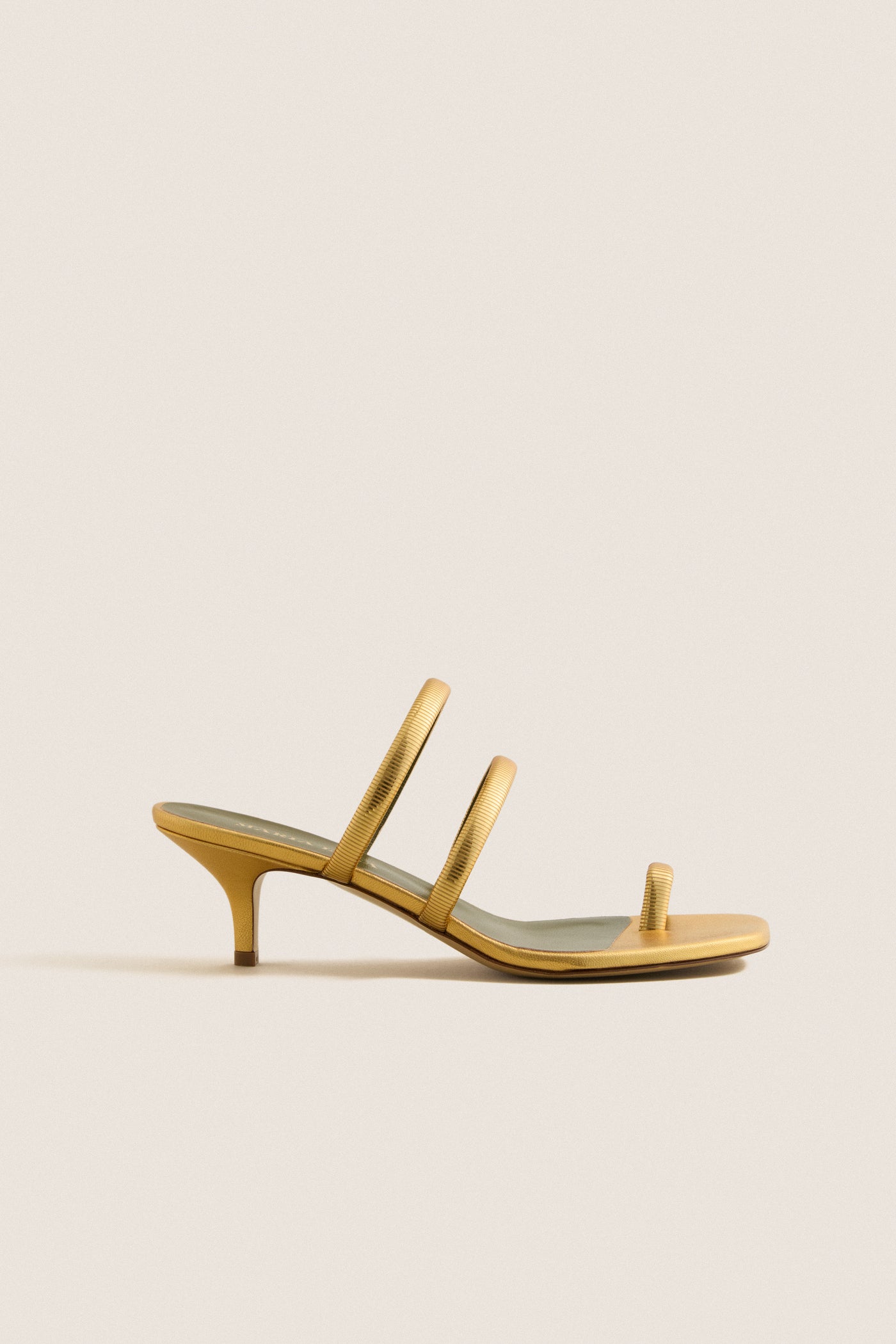 Gold Modia Sandals: Classic slip-on mule with a fun, effortless design featuring textured straps and a thin kitten heel, perfect for high-end, confident style.