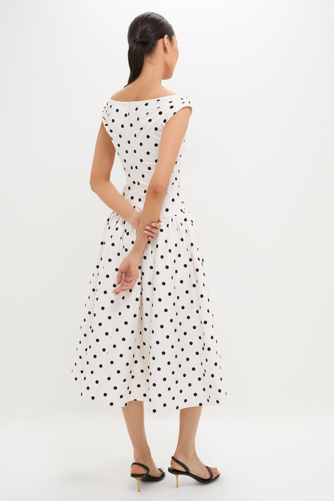 Woman in a classic Cream Polka Dot Cotton Midi Dress with an off-shoulder neckline and flared skirt, paired with black slingback heels for an effortless high-end look.