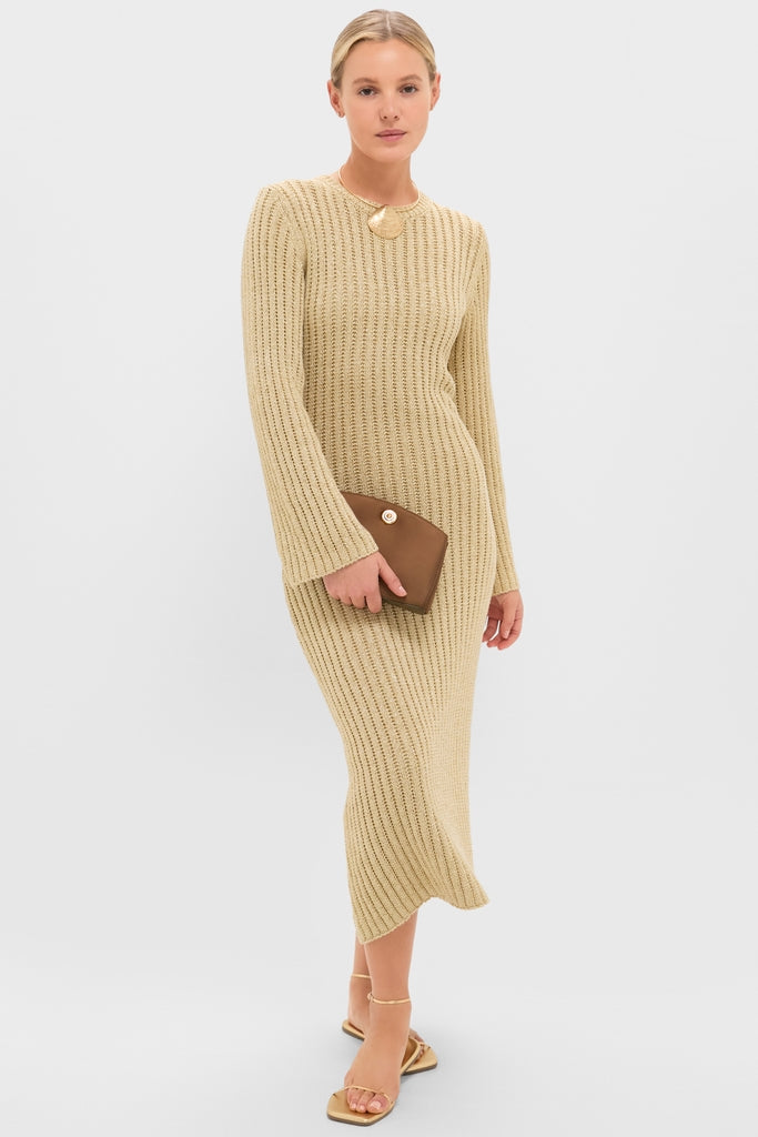 Model in a ribbed knit midi dress showcasing the Brown Satin Pushlock Clutch, an effortless, classic accessory. Paired with gold sandals and a sculptural pendant, exuding high-end, fun style.
