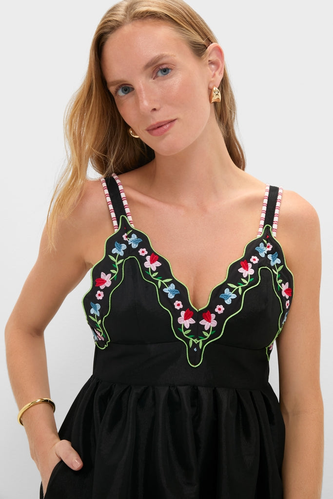 Black Selene Dress with colorful floral embroidery and striped straps, exudes effortless elegance. Paired with gold accessories, it embodies Tuckernuck’s classic, fun, high-end style.