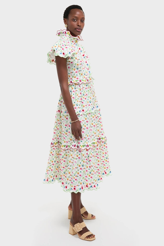 Model in profile wearing the White Nebula Dress, showcasing its classic, high-end design with a ruffled neckline, flutter sleeves, and effortless, fun floral print.