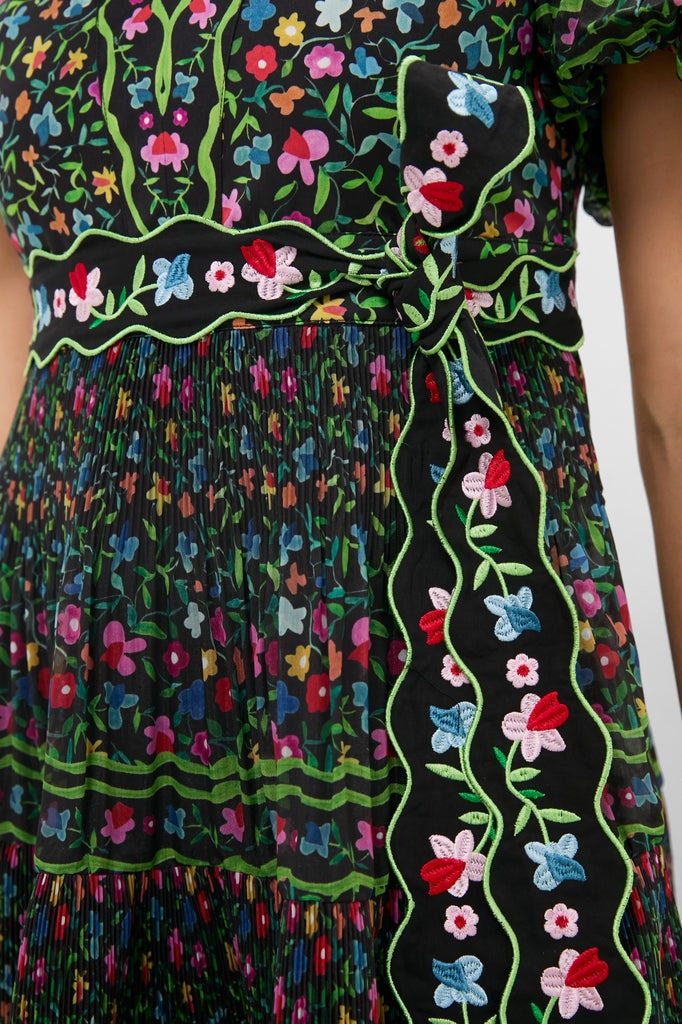 Black Celestia Dress: A classic, effortless midi with vibrant floral prints, puff sleeves, pleated skirt, and an intricately embroidered belt for a fun, high-end look.