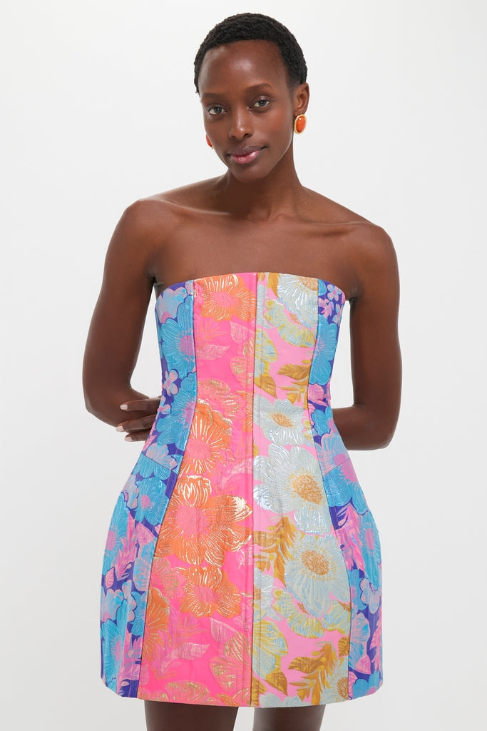 Dark-skinned woman in a classic, fun Multi Cosmica Dress showcasing effortless style with its structured silhouette, flared skirt, and bold floral metallic jacquard design.