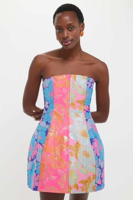 Dark-skinned woman in a classic, fun Multi Cosmica Dress showcasing effortless style with its structured silhouette, flared skirt, and bold floral metallic jacquard design.