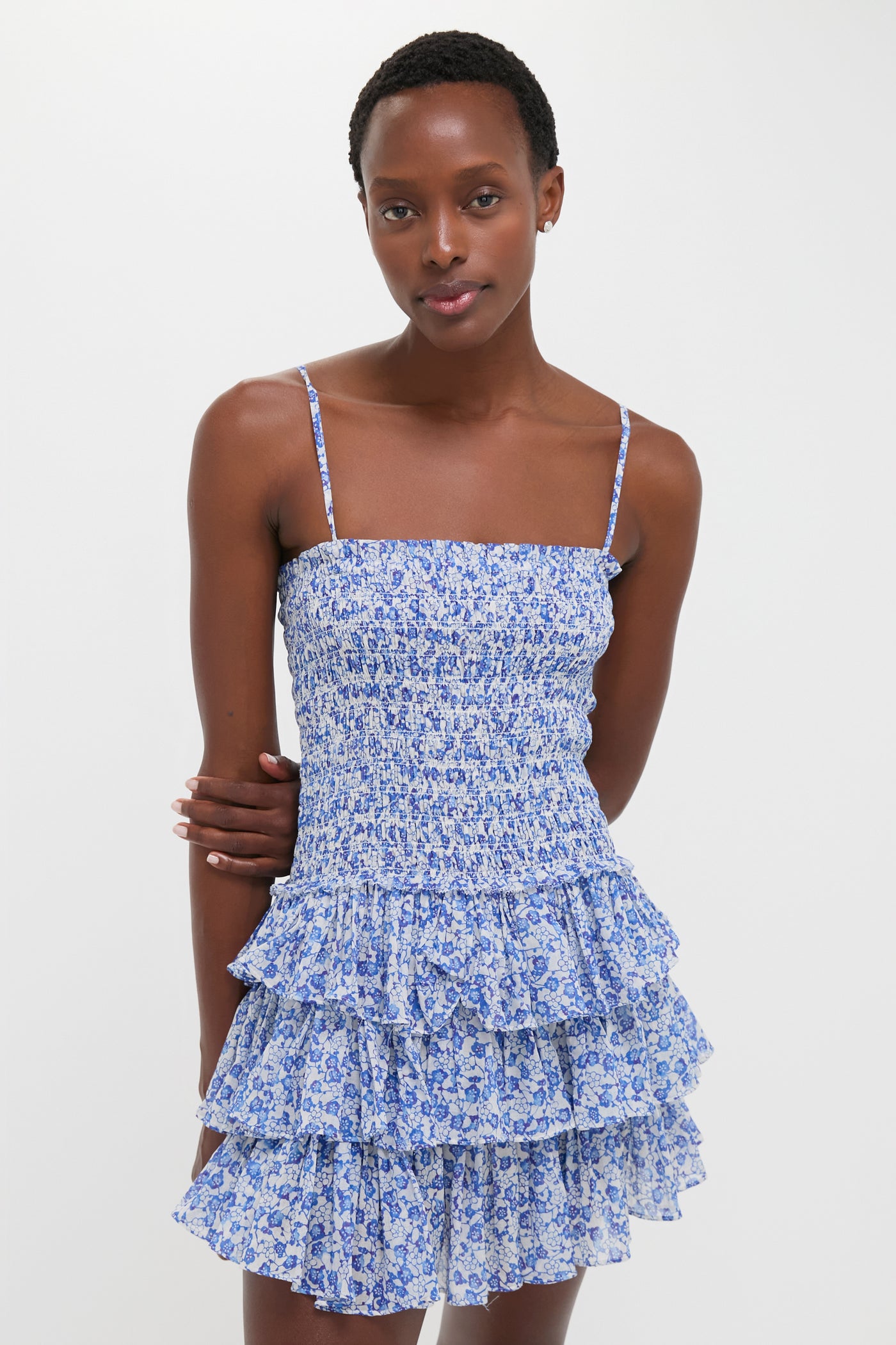 Young woman in a classic, effortless Blue Elodie Dress with a smocked bodice and tiered skirt, embodying fun, high-end style.