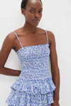 Blue Elodie Dress: A classic, effortless mini with a smocked bodice, tiered skirt, and floral print, perfect for fun, high-end summer days.
