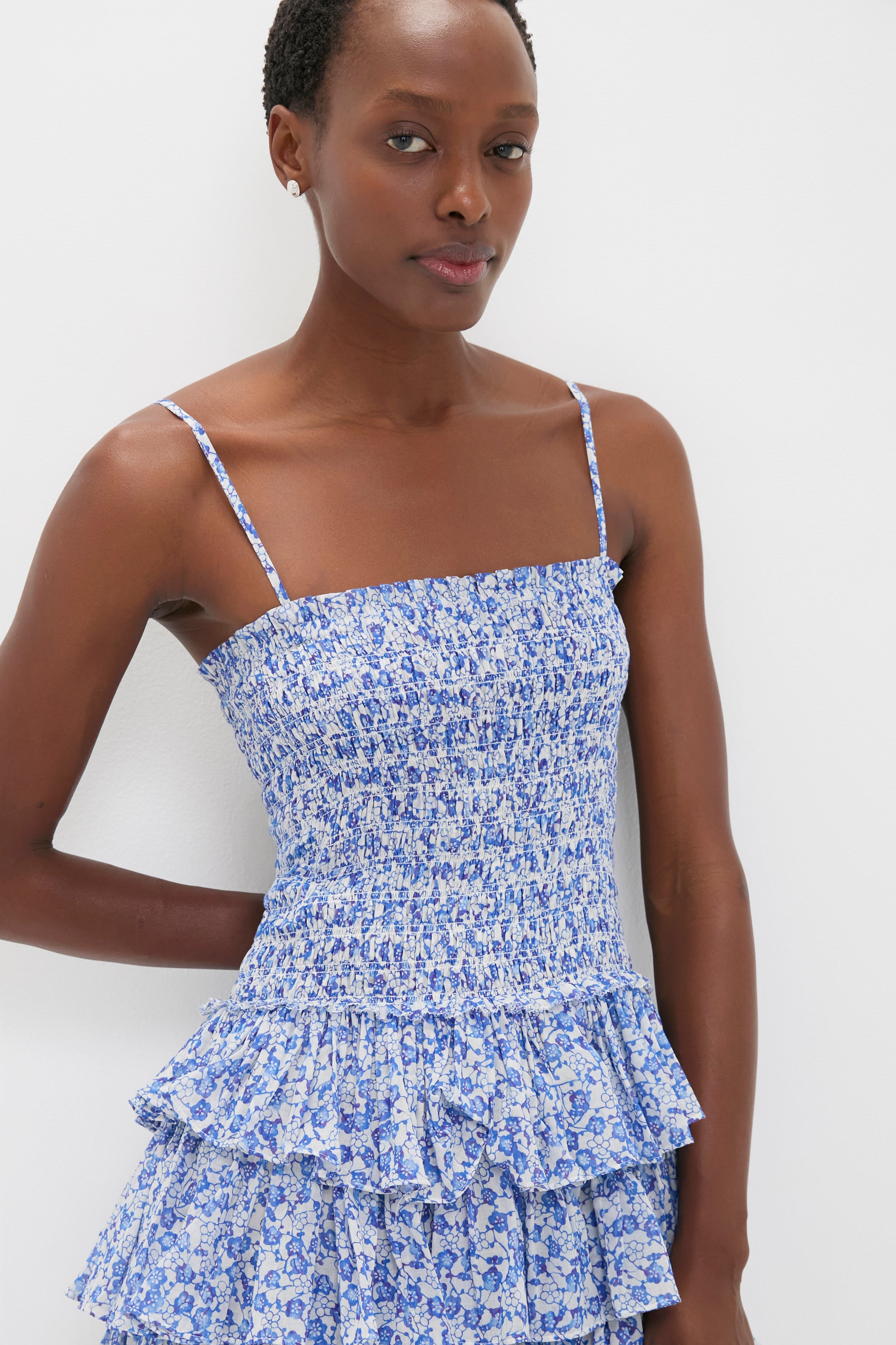 Blue Elodie Dress: A classic, effortless mini with a smocked bodice, tiered skirt, and floral print, perfect for fun, high-end summer days.